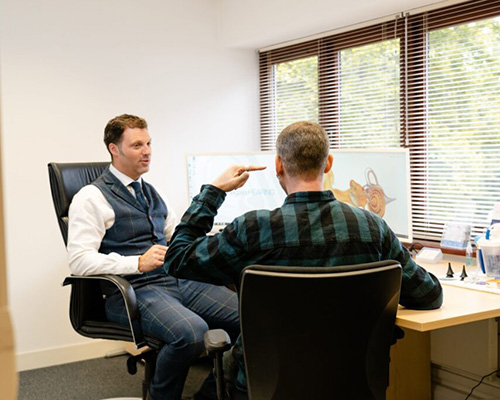 Audiologist speaking with client at Folkestone office