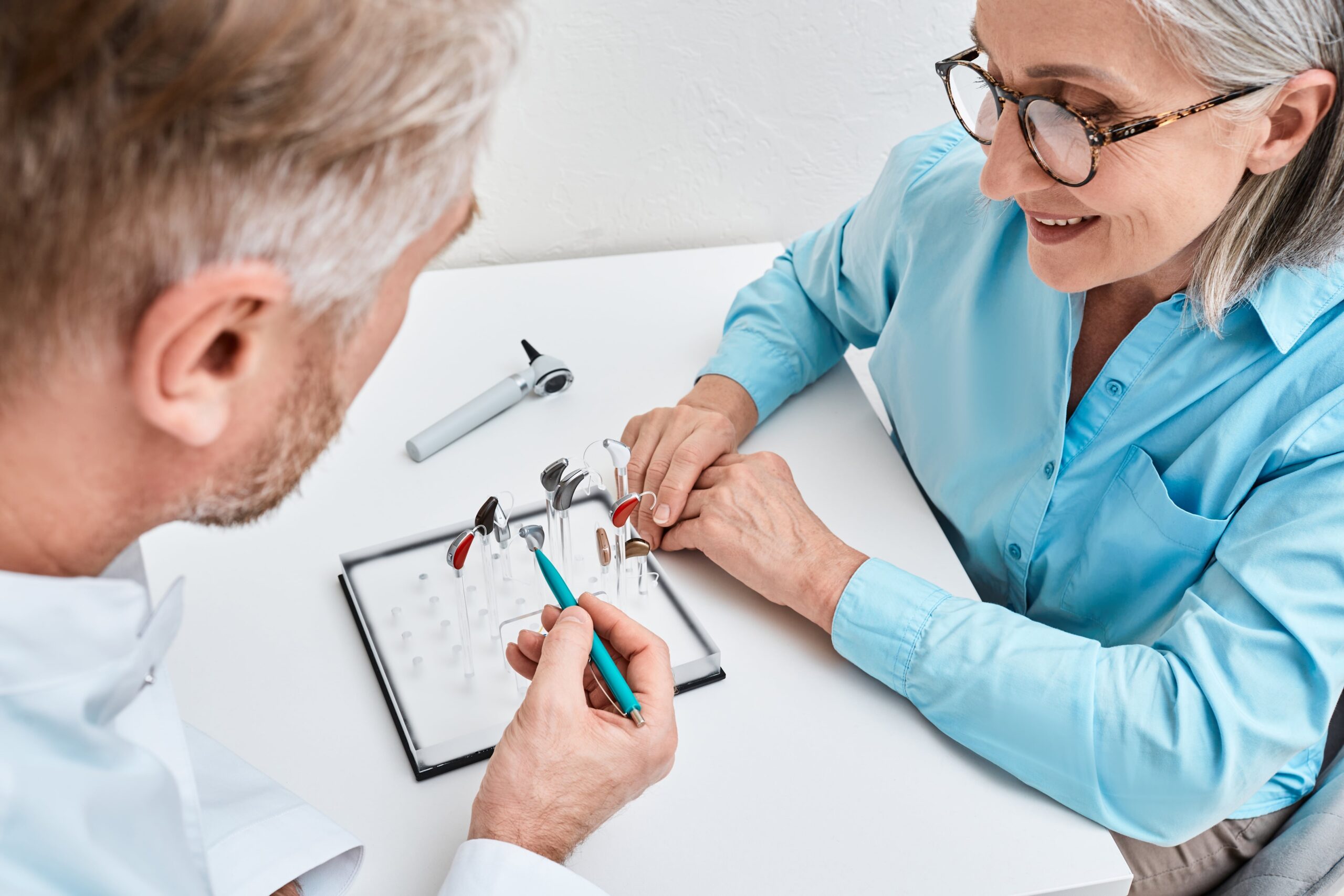 Audiologists helping client pick hearing aids.
